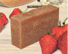 goat milk bar with strawberries on a wooden surface