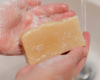 soapy hands holding bar of soap