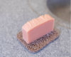pink bar of soap sitting on soap rest