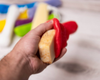 Hand holding red soap saver with bar of soap in it
