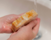 Goat milk bar lathered washing hands in a sink