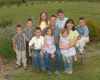 Jonas Family of eight posing outdoors in a grassy area.