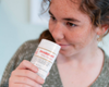 Women smelling deodorant smiling.