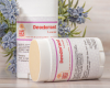 two tubes of natural deodorant with flowers in background