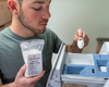 Fletcher scooping Goat Milk Laundry Soap into washing machine