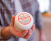 hand holding lotion tub
