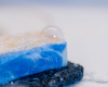 white bar of soap with a blue swirl sitting on soap rest