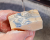 washing hands with mega size white bar of soap with blue swirl on top