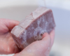 washing hands with purple bar of goat milk soap