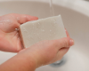 washing hands with bar of goat milk soap
