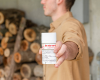Man looking straight ahead while holding the Goat Milk deodorant to his right
