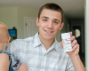 Hewitt holding a baby while showing off the Goat Milk Deodorant