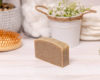 shampoo bar sitting on surface with a hairbrush and plant in background