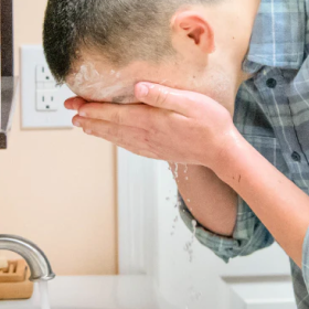 Man washing his face in the sink with the Goat Milk Soap