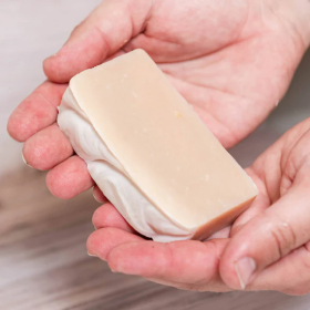 A Goat Milk Bar Soap resting on someone's hands