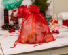 Red gift bag soap inside with a white bow on a red background