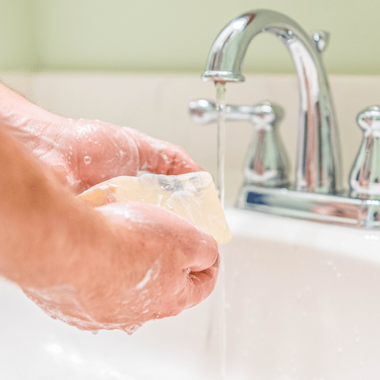 Washing hands in the sink with the Lavender Goat Milk Soap