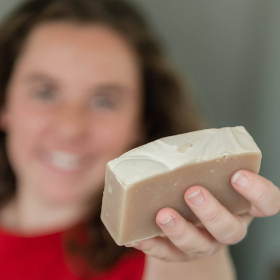 Indigo holding the Oatmeal Milk & Honey Goat Milk Soap