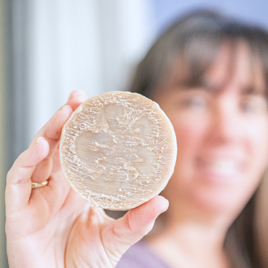 PJ holding bar of goat milk luffa soap