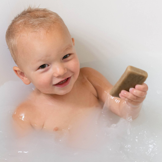 Michael in bath tub with bar of goat milk soap