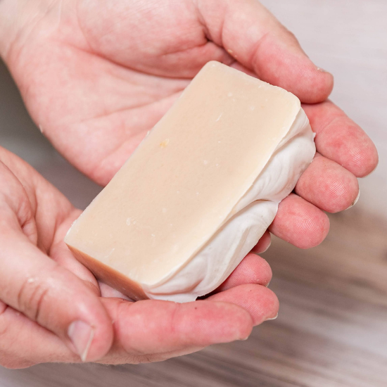 Purity Goat Milk Soap bar resting on open hands
