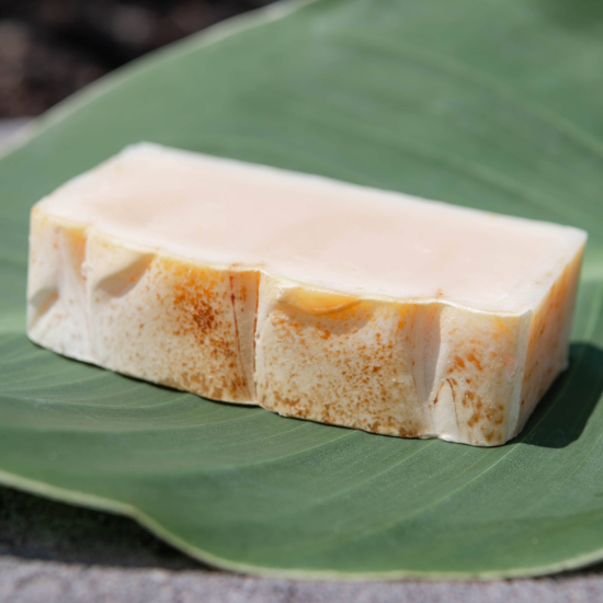 Tea Tree Goat Milk Soap bar resting on a large green leaf