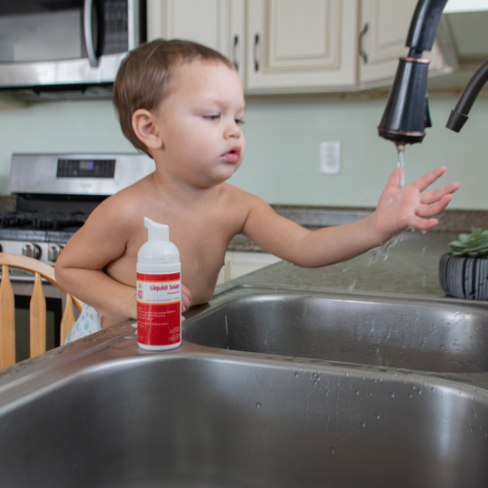 Landon washing hands with liquid goat milk soap at sink