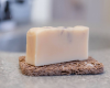 white bar of soap with purple swirl on soap rest