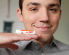 Hewitt with goat milk lip balm on his fingers near his face