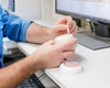 Person holding a tub of goat milk lotion at a desk