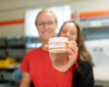 Two people holding a tub of solid lotion