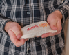 hands holding luffa soap in cotton bag