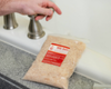 Goat Milk Bath bag laying on side of tub