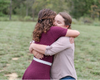 Indigo and Brett hugging in a field