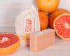 Close-up of grapefruits soap bars on a wooden surface.