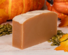 Bar of goat milk soap with pumpkins on a wooden surface