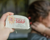 holding shampoo bar in cotton bag with Indigo in the background