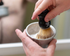 using a shave brush to lather shaving soap in a bowl