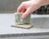 hand placing green bar of goat milk soap on Soap Rest